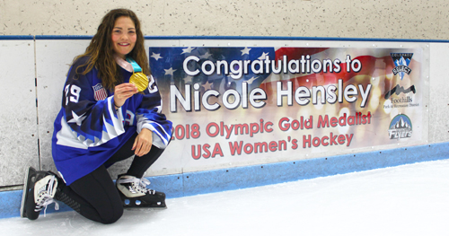 Olympic gold medalist Nicole Hensley from Women's U.S. Hockey Team posing with her 2018 gold medal at the Edge Ice Arena.