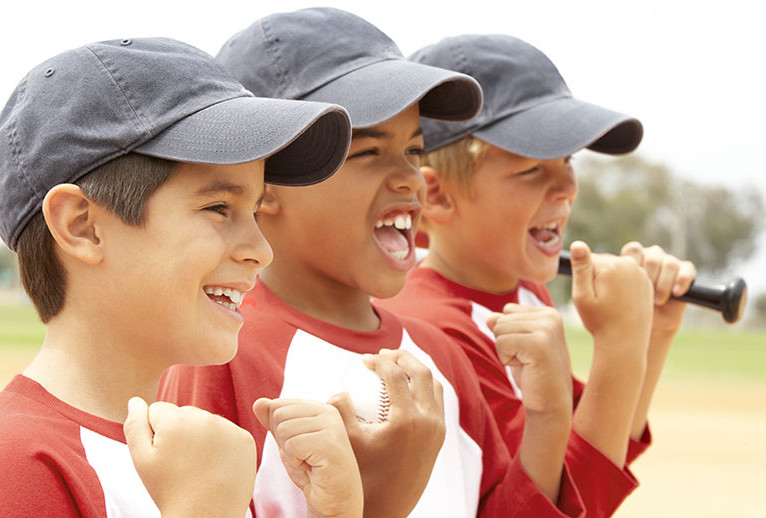 Three young boys dressed for baseball