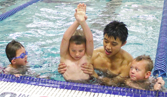 Swim instructor teaching children how to swim.