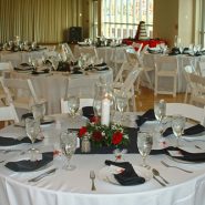 A wedding reception with round dining tables and chairs