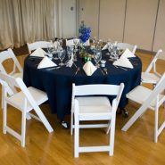 A wedding reception with round dining tables and chairs
