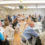 A wedding reception with round dining tables and chairs