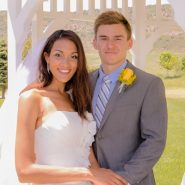 A bride and groom posing under a gazebo