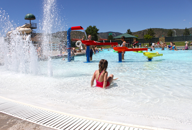 People playing in an outdoor pool.