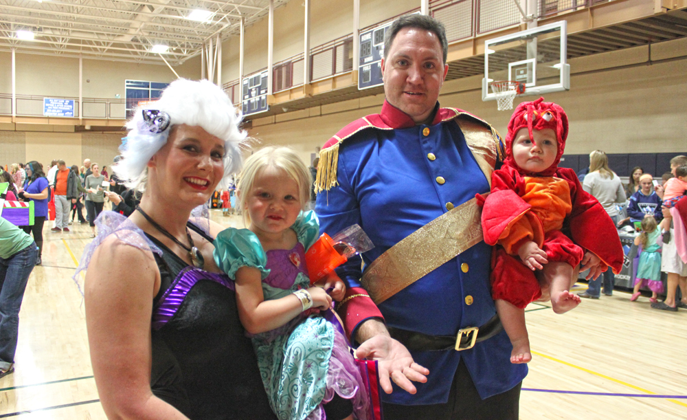 A family dressed in costume for trick-or-treating.