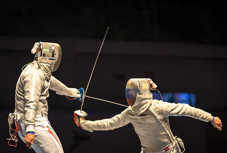 Two individuals in the sport fencing.