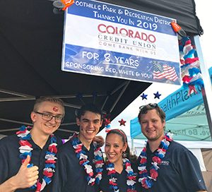 A group of employees from Colorado Credit Union working their vendor booth at the Red, White & You event.