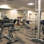 Several different pieces of weight lifting equipment and free weights in the cardio weight room in Lilley Gulch Recreation Center.