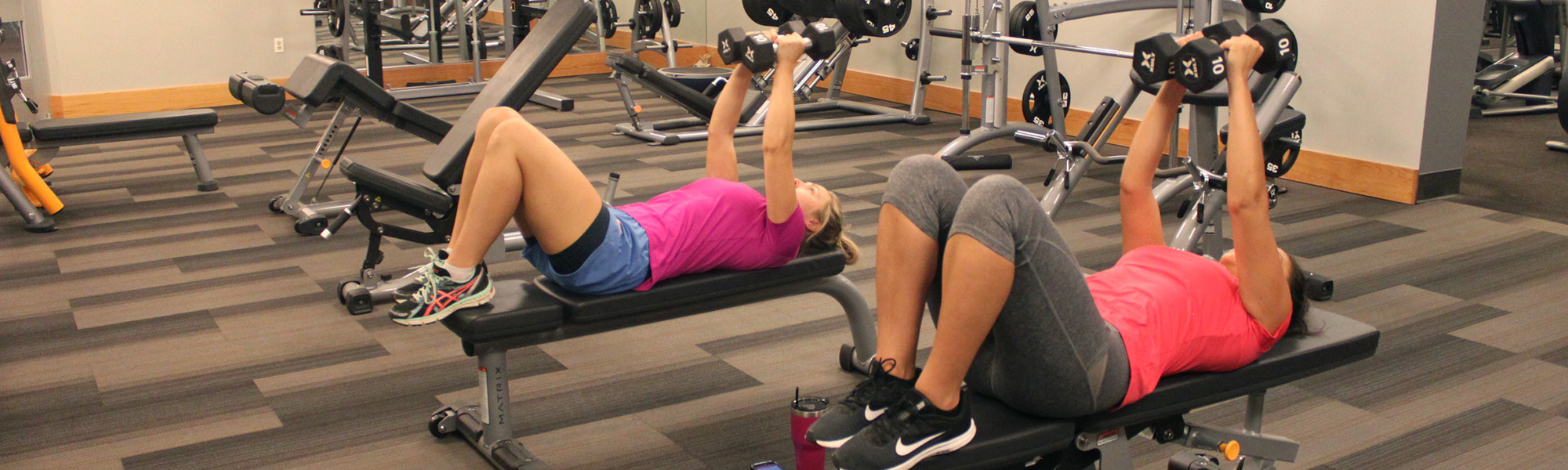 Two women exercising with hand weights.