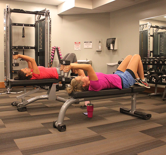 Two women exercising with hand weights.