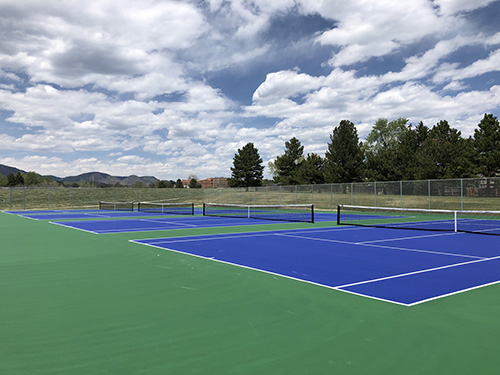 Tennis courts at Lilley Gulch Park with mountain views in the background.