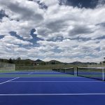 Tennis courts at Lilley Gulch Park with mountain views in the background.