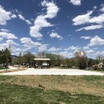 Trappers Glen Park showing sidewalks, park shelter, basketball pad, playground and mountain views on a blue sky day.