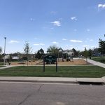 Street view of Trappers Glen Park showing sidewalks, park sign and playground.