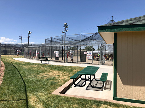 Outside view of the batting cages showing picnic benches for spectators.