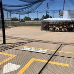 View inside the batting cages from an individual stall looking at the machines.