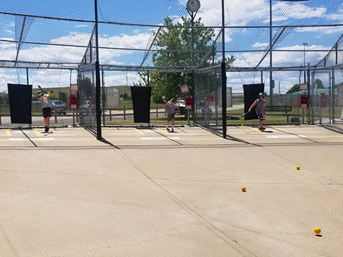 Youth practicing their batting skills at the batting cages