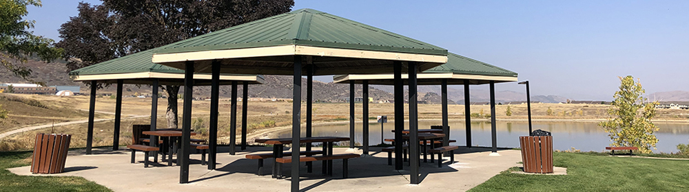 A cluster of park shelters overlooking a lake and mountains at Easton Regional Park