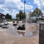 Children playing in different splash features at the Splash Park in Clement Park