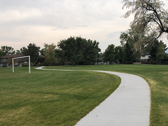 Sidewalk meandering through green grass in Valley View Park