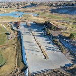 Aerial image of the parking lot at Meadows Golf Club including the clubhouse, driving range and course views.