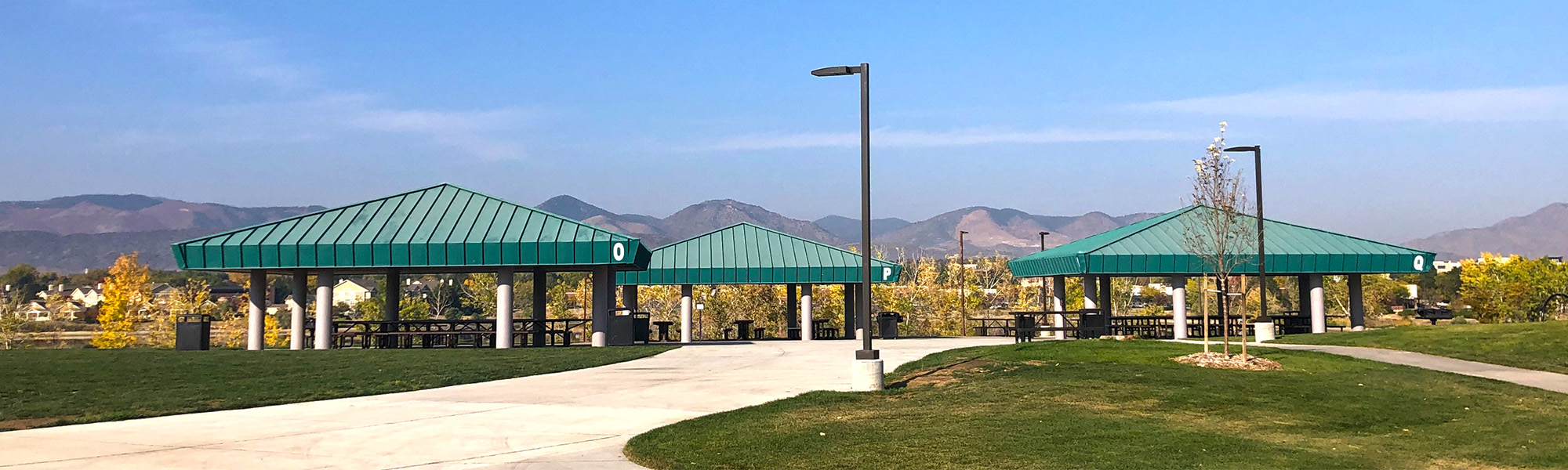 Scenic image of Shelters O, P and Q in Clement Park with mountains in background.