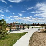 Sidewalk view leading to the playground and park shelters in Alpers Farm Park.