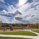 Street view of park featuring sidewalks, playground, park benches in Eagle Meadows Park.