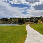 Sidewalk leading to two tennis courts.