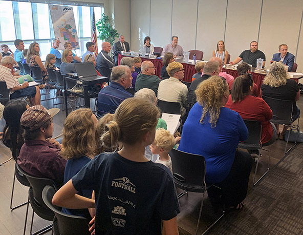 Board of directors meeting with residents sitting in audience.