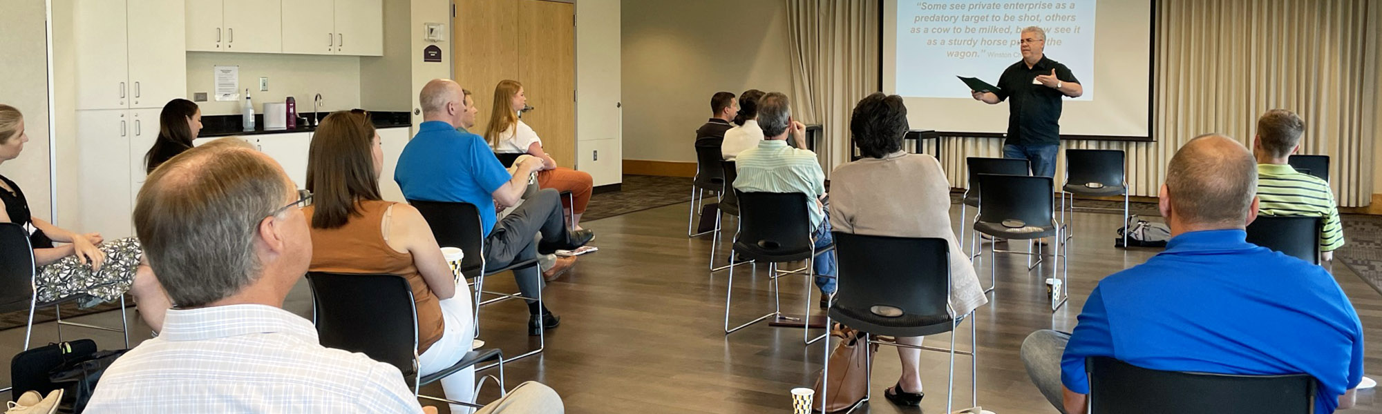 Group of people attending a meeting watching a presentation.