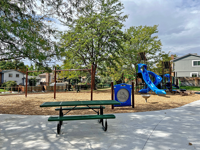 View of playground, swings and picnic table.