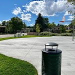 Half basketball court with basketball hoop and trash can.