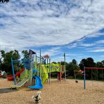 Colorful playground equipment, swings and rockers.