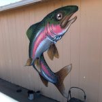The side of a shed painted with a realistic looking rainbow trout