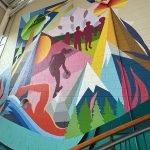 A colorful art mural showcasing different aspects of indoor and outdoor recreation with features like mountains, a swimmer, a basketball player, trees, birds, children holding hands and a heart.