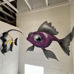Two colorful fish painted on walls inside the bath house
