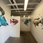 Four different colored fish painted on walls inside the bath house