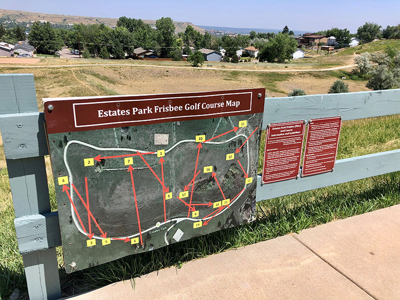 A directional map for Estates Park Frisbee Golf posted on a fence near the course area