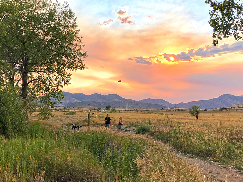 Disc golf players during a pretty sunset behind the mountains in Fehringer Ranch Park