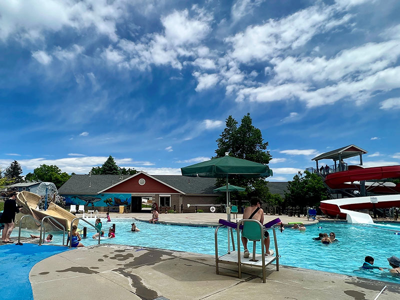 A lifeguard watching people swimming and using the slides in the pool