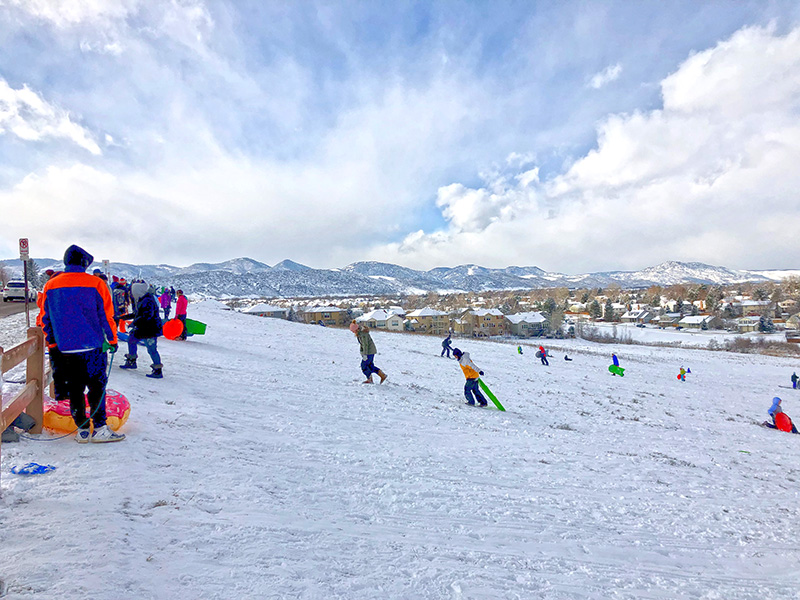 People on a snowy hill sledding