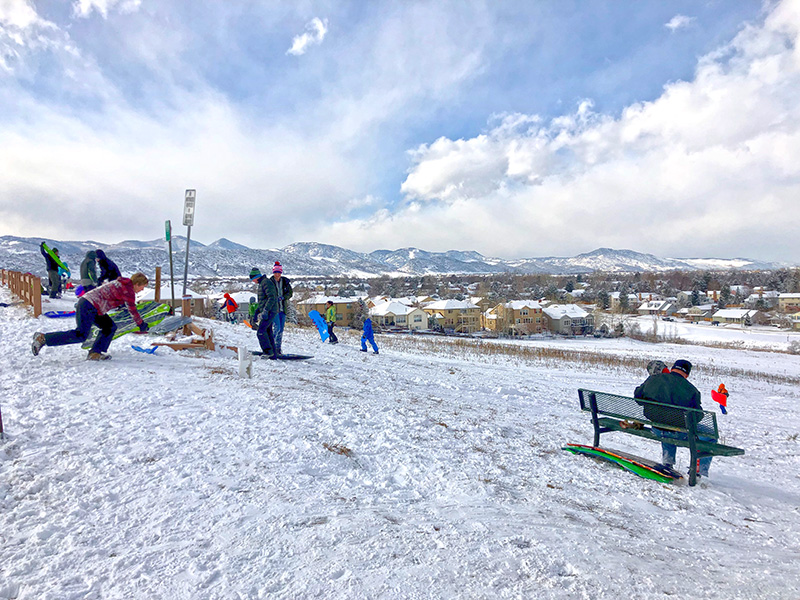 People on a snowy hill sledding