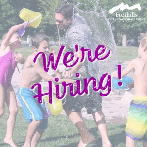 Summer camp counselor playing with kids. The words "We're Hiring".