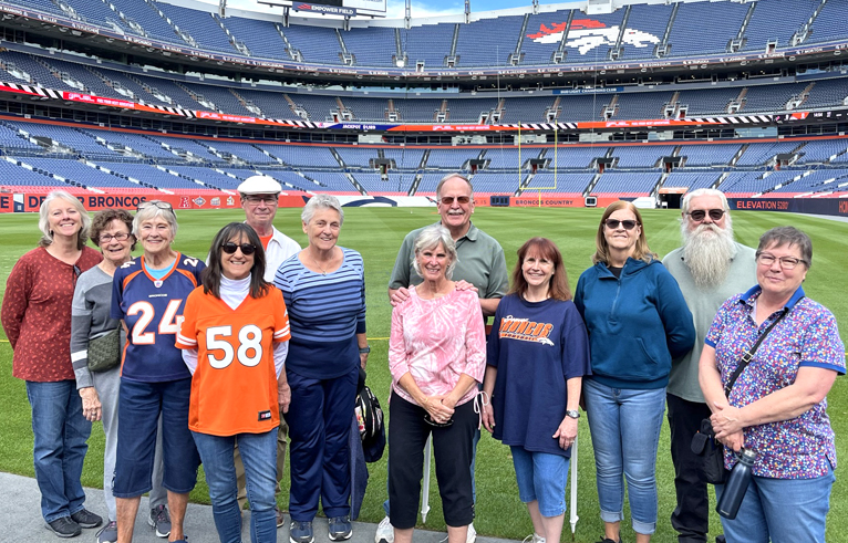 A group of adults inside the Denver Broncos stadium.