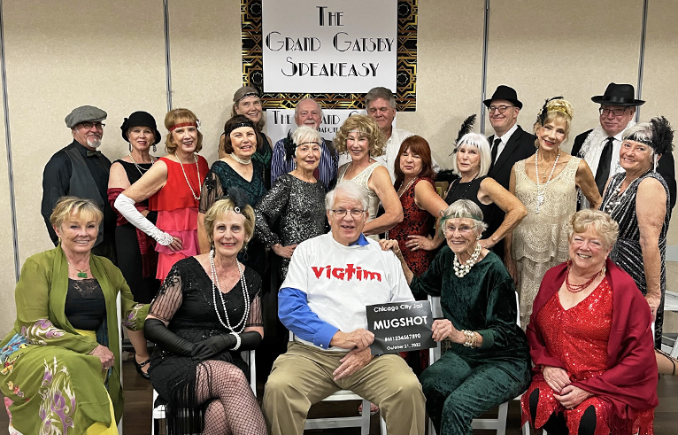 A group of adult dressed in costumes for a murder mystery dinner party.
