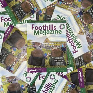 Multiple copies of Foothills Magazine displayed to highlight the cover.